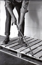 A man using a crowbar on a pallet